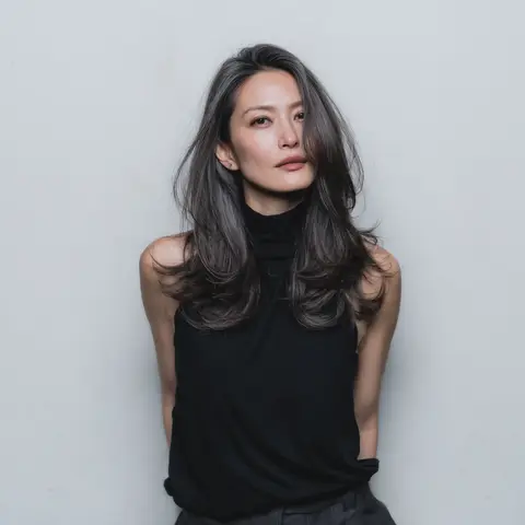 グレイヘアが混じる髪に顔まわりの段差と大きなカールを合わせたロングヘア